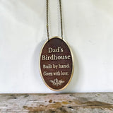 Bronze plaque with engraved text 'Dad's Birdhouse Built by hand. Given with love.' on a white background.