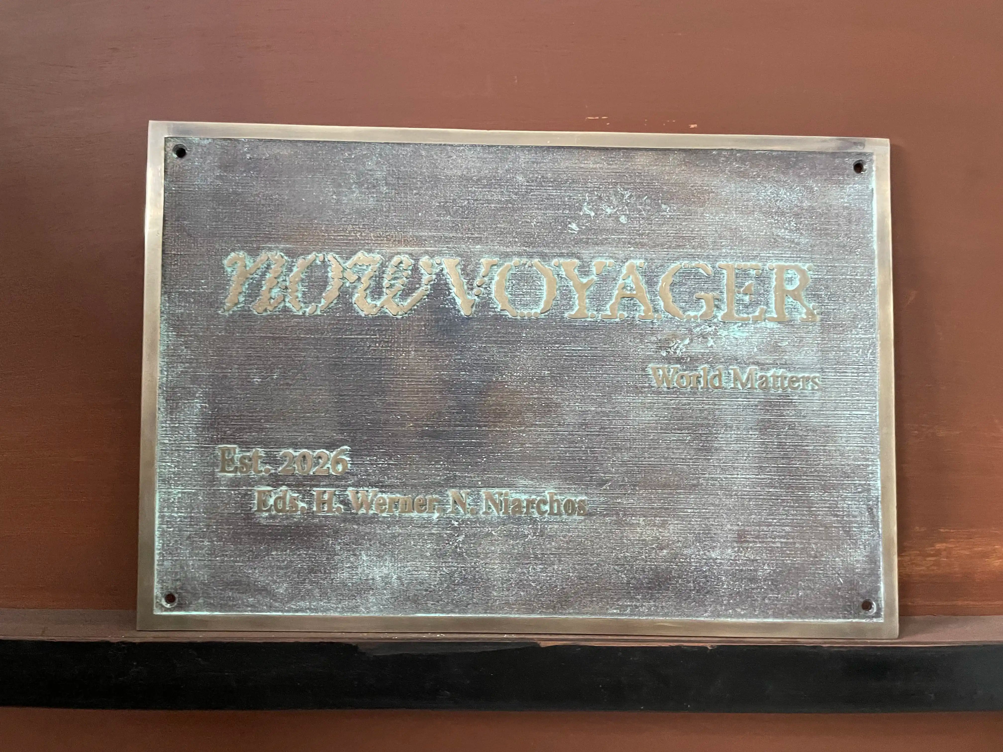 Bronze plaque with 'NOWVOYAGER' branding on a brown background