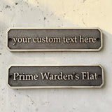 Two customizable nameplates on a textured surface