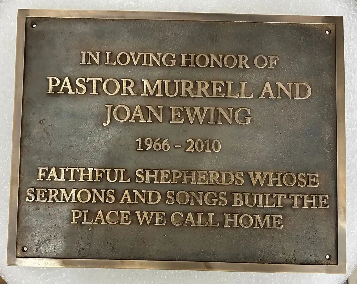 Bronze plaque honoring Pastor Murrell and Joan Ewing with text on a white background
