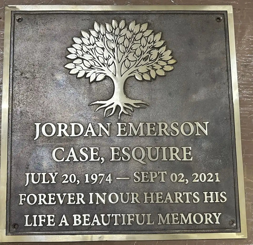 Memorial plaque with a tree design and engraved text on a metallic background