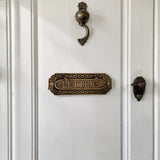 Vintage-style letter box on a white door with brass hardware