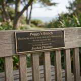 Wooden bench with a plaque dedicated to 'Poppy's Bench' in a natural setting.