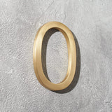 Solid brass address numbers with floating hidden stud mounting for modern home exteriors and entryways.