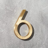 Solid brass floating room and door numbers with hidden studs for offices, hotels, apartments, and interior spaces.