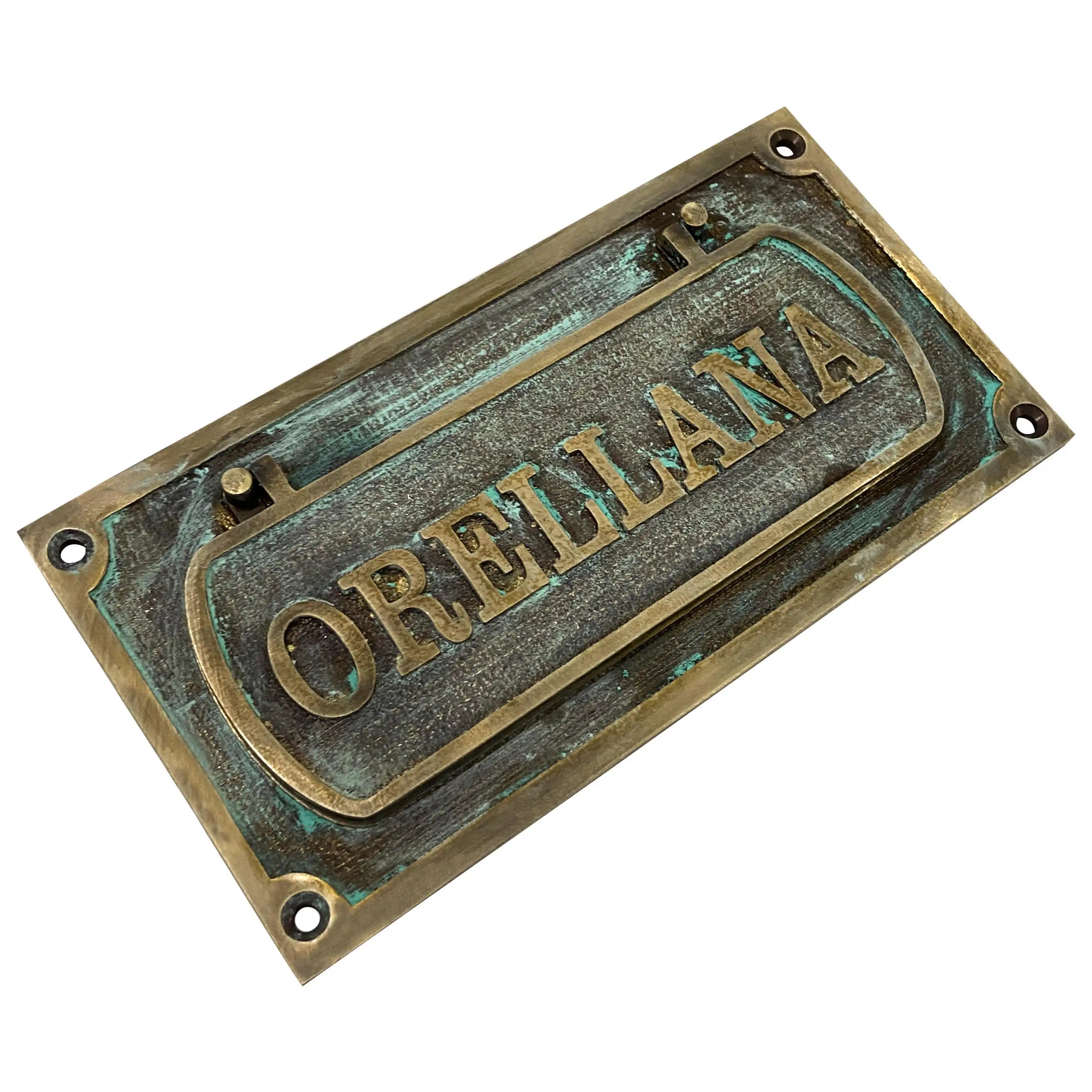 Vintage brass mail slot for door showing antique finish texture