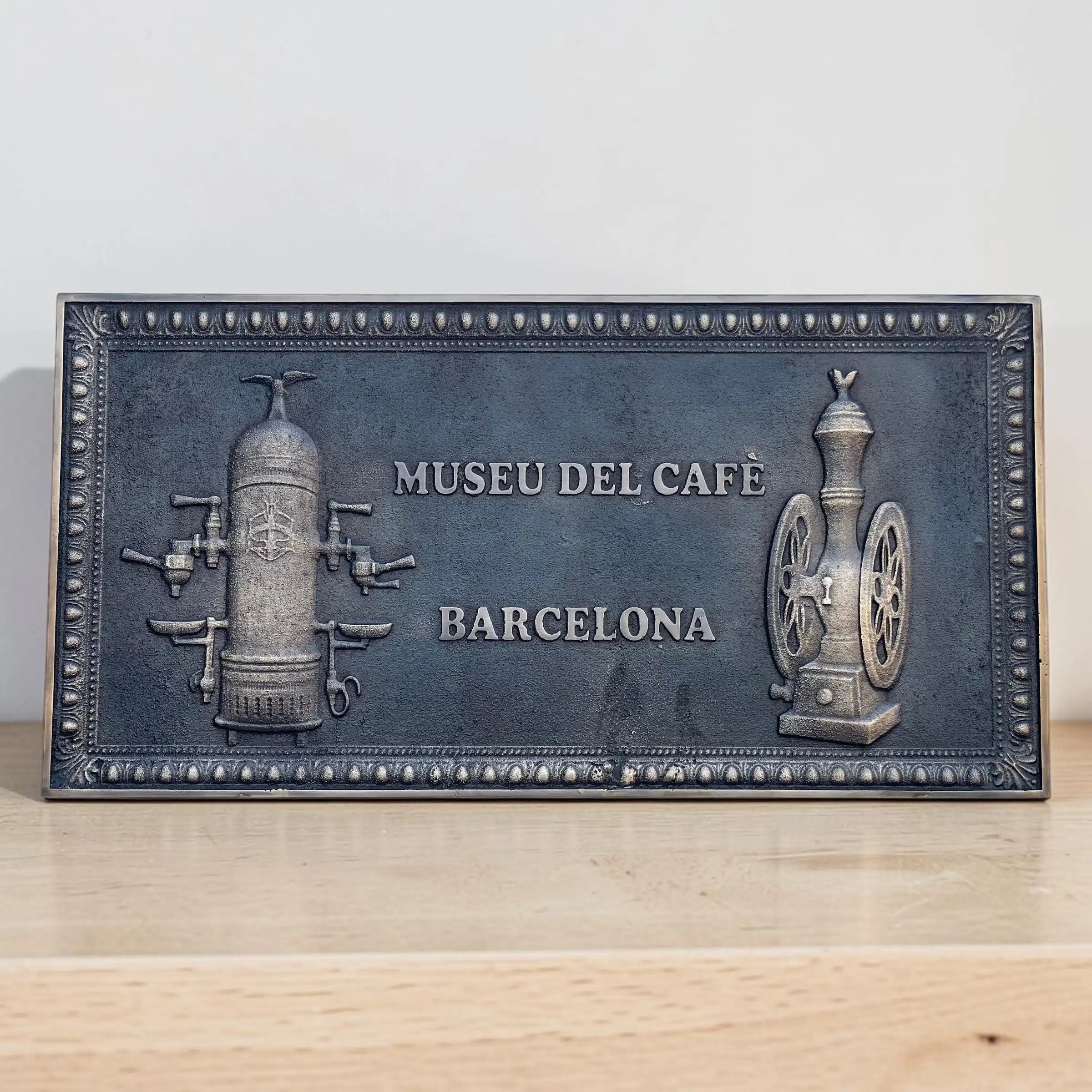 Bronze plaque for Museu del Cafeè Barcelona on a wooden surface