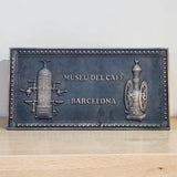 Bronze plaque for Museu del Cafeè Barcelona on a wooden surface