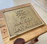 Brass plaque with 'MAISON LAVAILLE' on a wooden surface