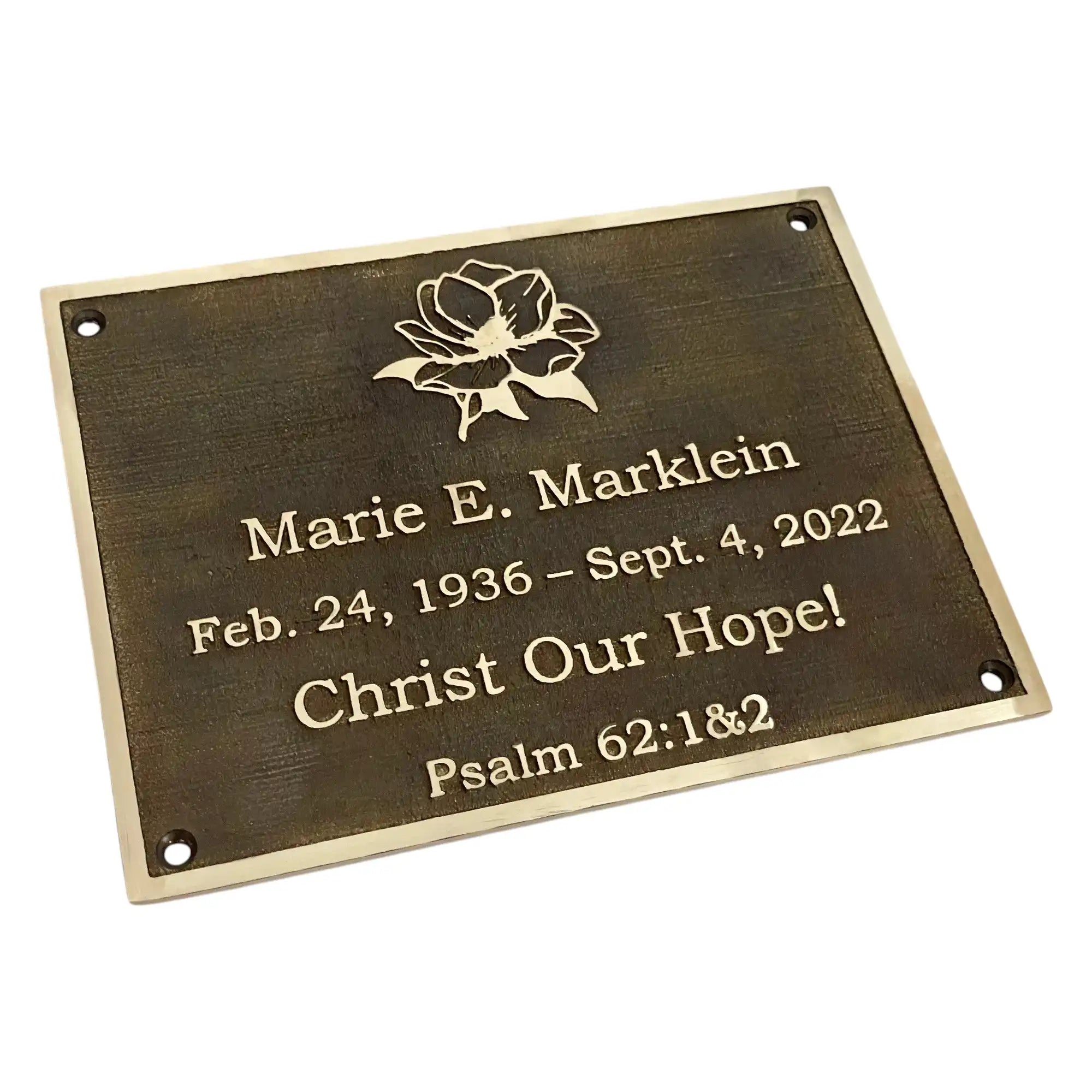 Memorial plaque with engraved text and a flower design on a white background