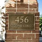 Address sign on a brick wall with '456 Second Street' text