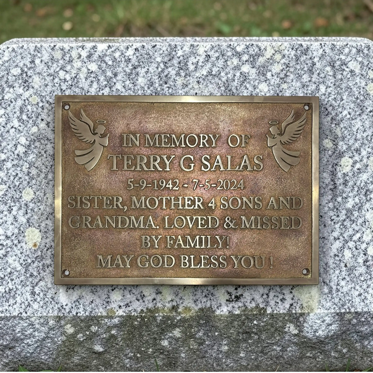 Bronze plaque on a stone wall with engraved text in memory of Terry G Salas.