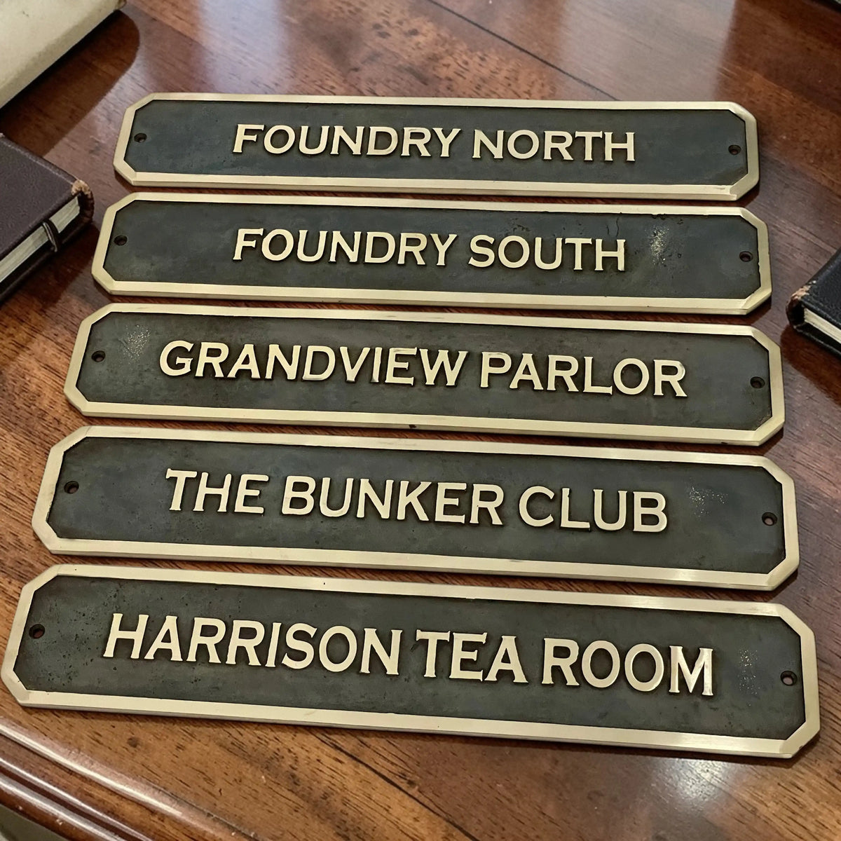 Set of decorative Bronze signs with names on a wooden surface