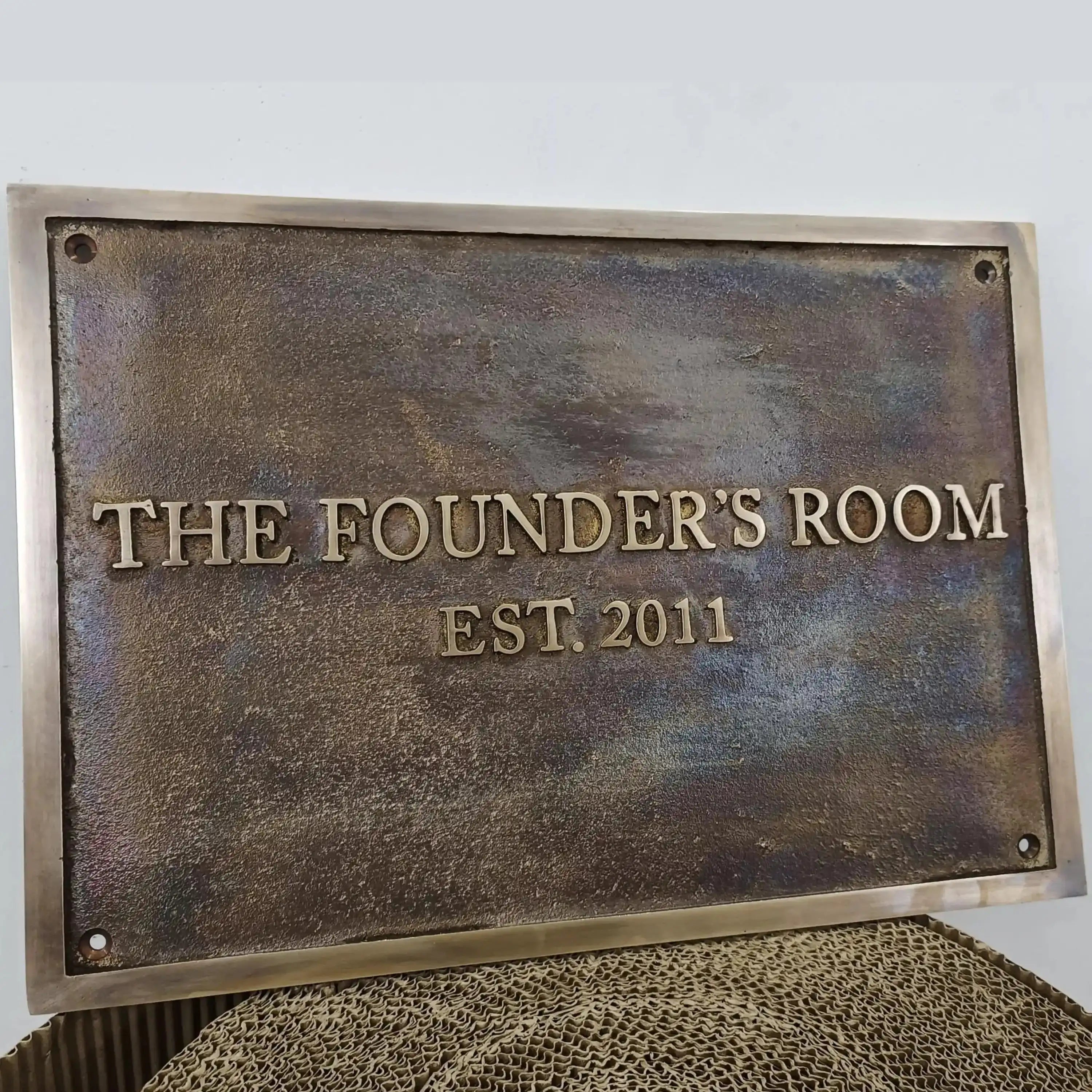 Bronze plaque with custom  text on a textured surface.