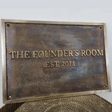 Bronze plaque with custom  text on a textured surface.
