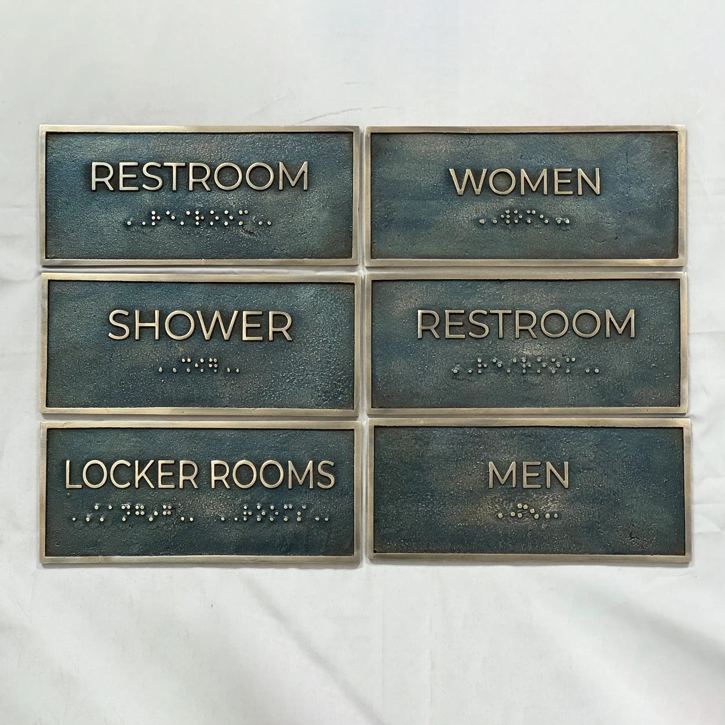 Custom metal nameplate sign antique finish - Set of restroom signs with Braille text on a white background