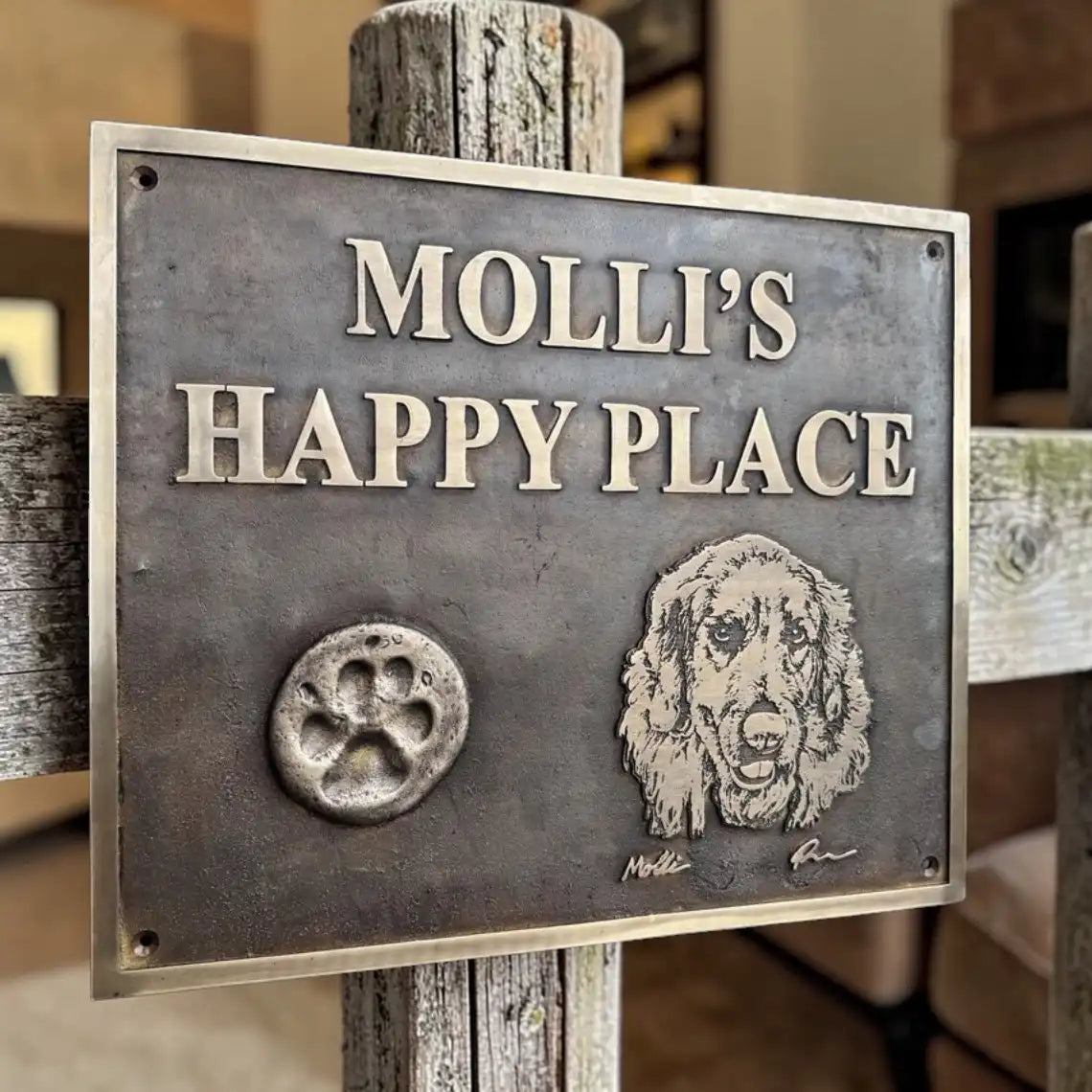 Metal sign with 'MOLLI'S HAPPY PLACE' and a dog illustration on a wooden post.