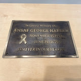 Memorial plaque for Ansaaf George Habeeb on a wooden surface