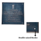 Memorial plaque with engraved text and cross symbol on a blue background