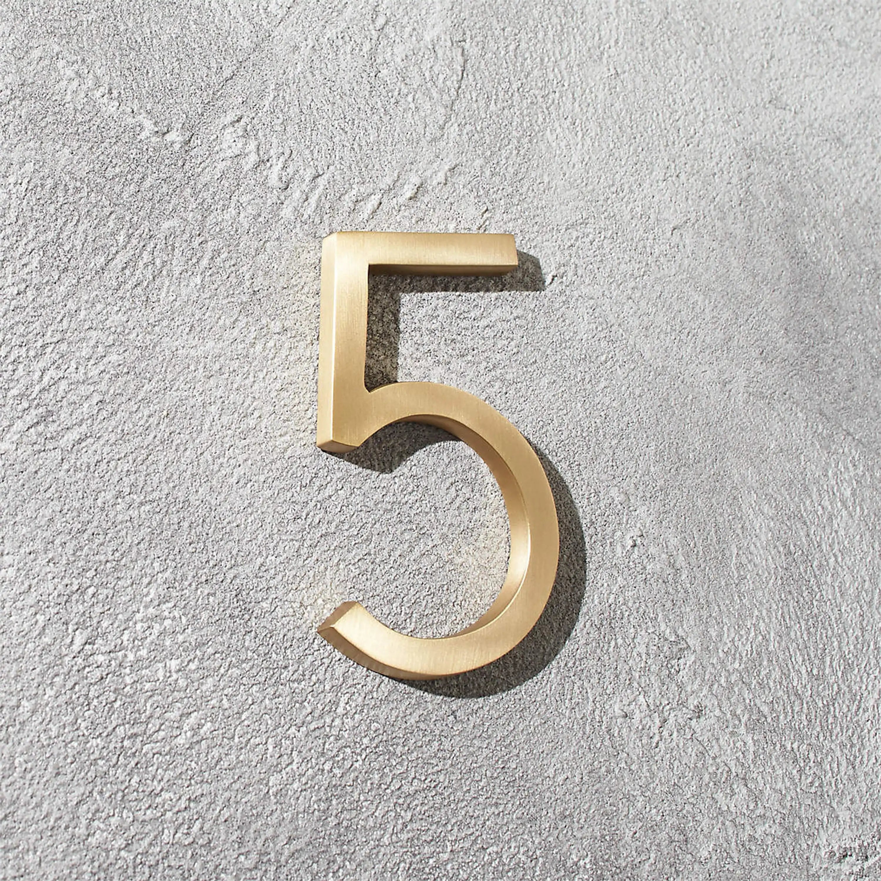 Modern solid brass house numbers featuring concealed stud mounting for a clean floating appearance.