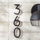 Modern floating black house numbers mounted on exterior wall with hidden studs for a clean contemporary address display