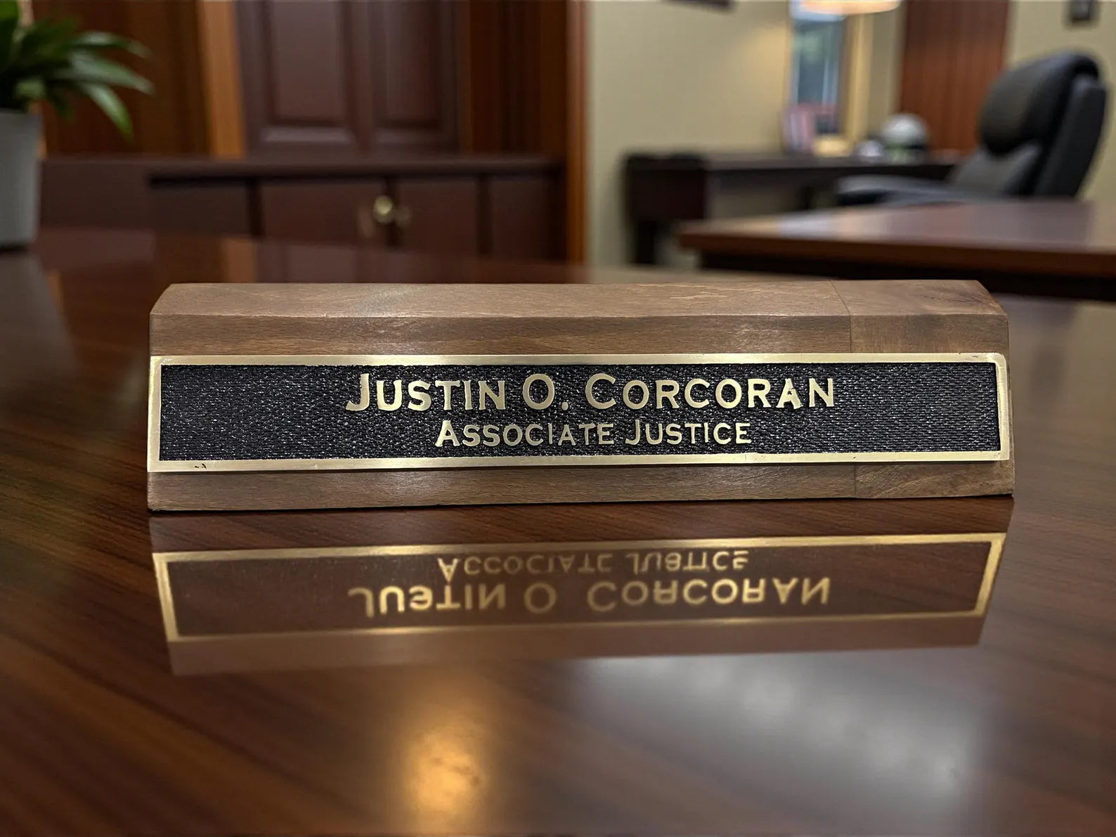 desk nameplate with engraved text on a reflective surface