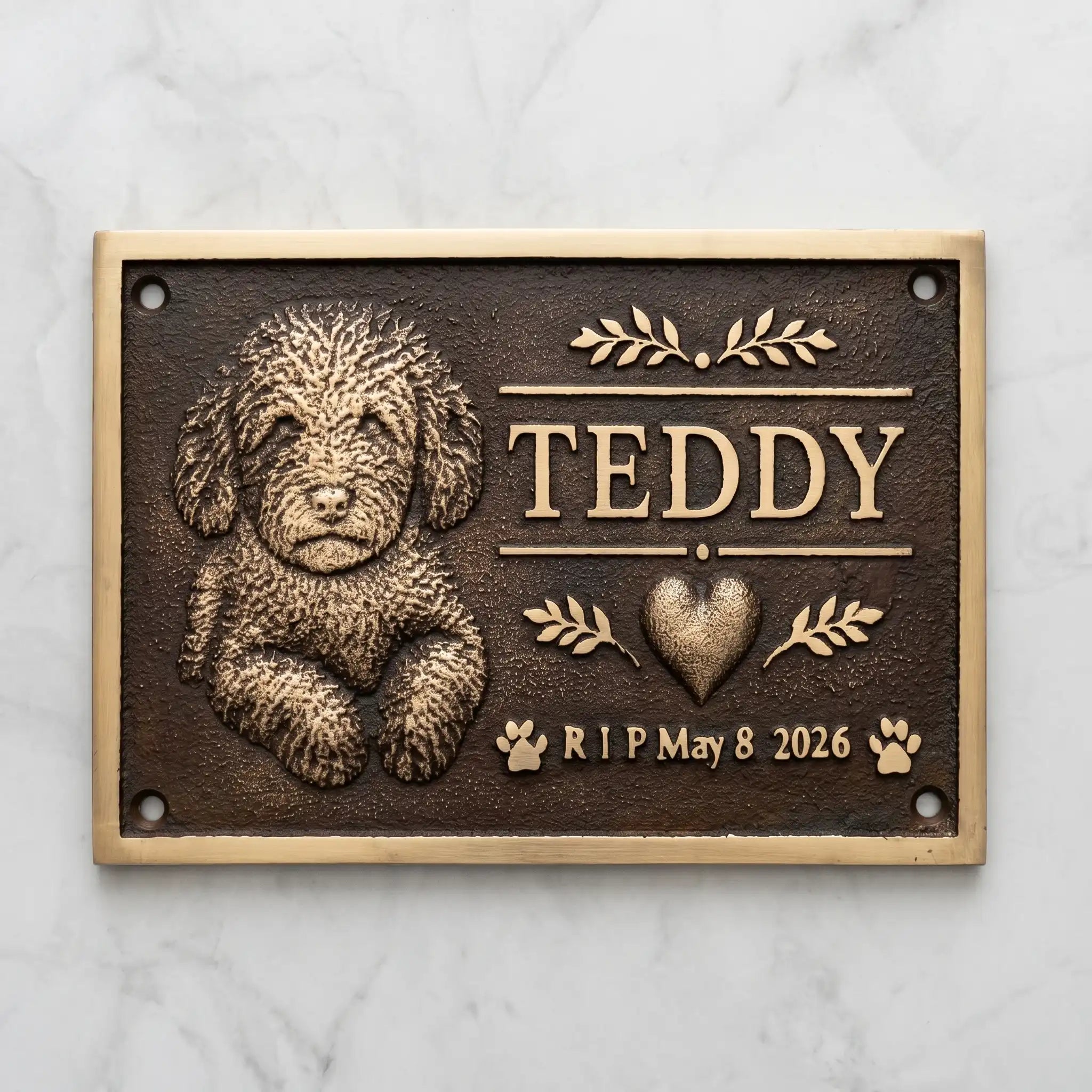 Bronze Memorial plaque for a dog named Teddy with a heart and dates on a marble background
